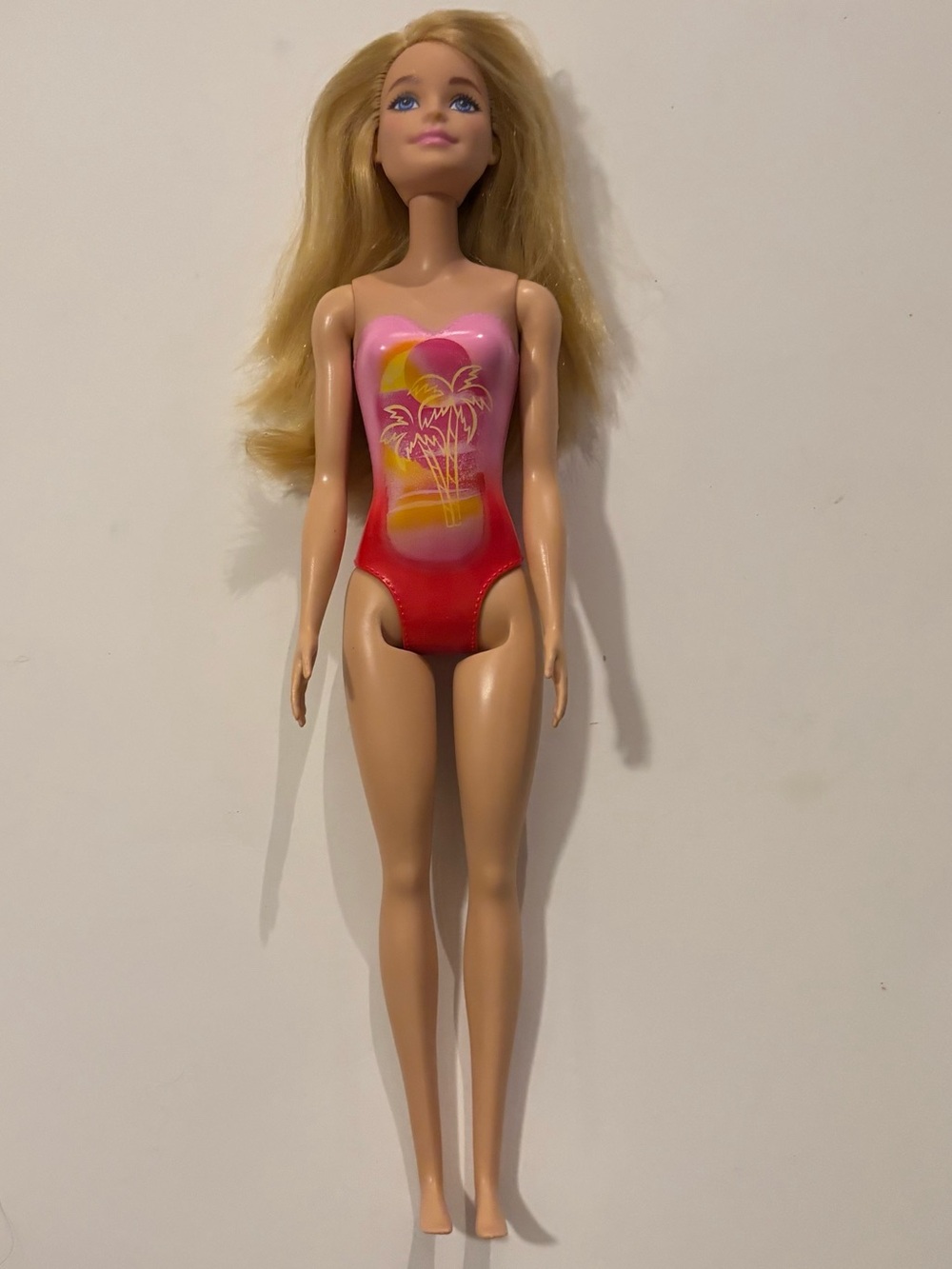 Barbie Beach Doll with blond hair and a pink palm tree-print swimsuit